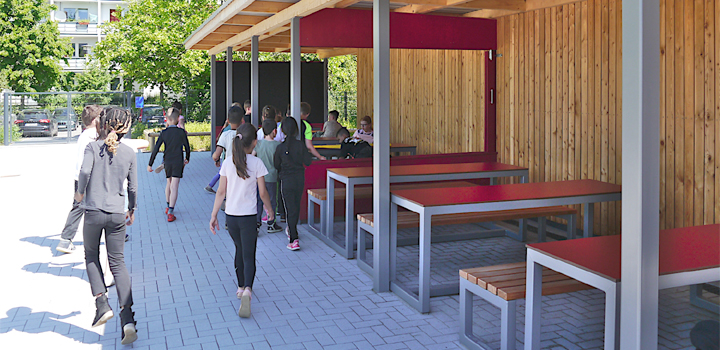 Kinder sind Aufenthaltsbereich im Freien mit Holzwänden, Metallrahmen, Tischen und Stühlen