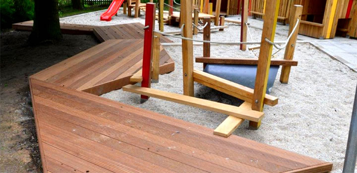 Kombinierte Holzpodestlandschaft auf einem Spielplatz, integriert in Spielgeräte, möglicherweise von FreiraumObjekte Ney GmbH.