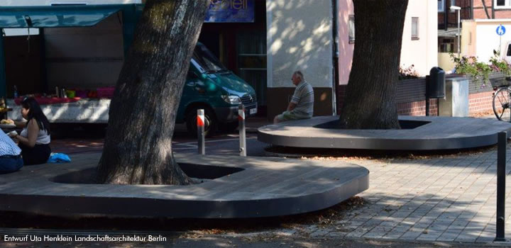 Ovale Sitzbank aus Holz und Metall um einen Baum, möglicherweise von FreiraumObjekte Ney GmbH.