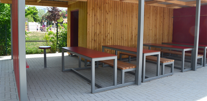 Mehrere überdachte Sitzgruppen aus Holz und Metall im Außenbereich, möglicherweise von FreiraumObjekte Ney GmbH.
